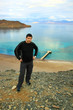 Man standing on mountain in front of blue sea and sky