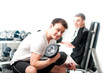 Two guys lifting dumbbells in sportclub on white background Two guys lifting dumbbells in sportclub on white background