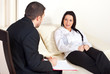 Photo: Patient woman talking with psychologist man Patient woman talking with psychologist man
