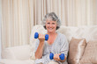 Foto: Woman doing her exercises on her sofa Woman doing her exercises on her sofa