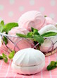 White and pink marshmallows with mint leaves in a basket White and pink marshmallows with mint leaves in a basket