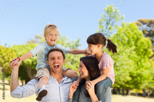 Photo: Parents giving children a piggyback Parents giving children a piggyback