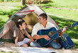 Father playing guitar with his son