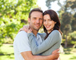 Radiant couple hugging in the park