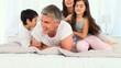 Children tickling their father