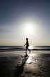 Photo: Woman strolling on the beach at sunset Woman strolling on the beach at sunset