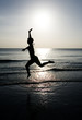Photo: Woman leaping on the beach at sunset Woman leaping on the beach at sunset