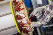 skilled industrial worker inserting the field coil into armature