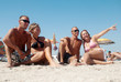 Portrait of happy girls and guys lying on sand on summer vacatio Portrait of happy girls and guys lying on sand on summer vacatio