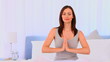Peaceful woman practicing yoga on her bed