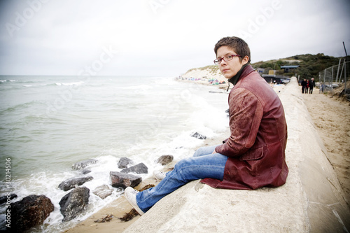 Photo: Woman relaxing by the sea in winter Woman relaxing by the sea in winter