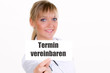 junge frau zeigt schild-termin vereinbaren