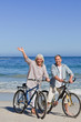 Photo: Mature couple with their bikes on the beach Mature couple with their bikes on the beach