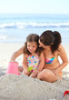 Daughter with her mother making a sand castle
