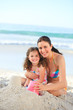Daughter with her mother making a sand castle