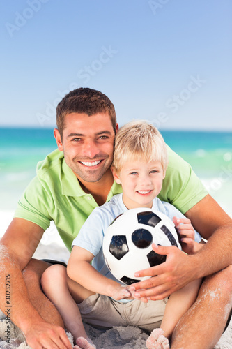 Photo: Happy father playing football with his son Happy father playing football with his son