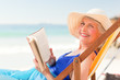 Elderly woman reading a book at the beach Elderly woman reading a book at the beach