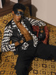 Man with leather mask sit on sofa.