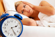 Schlaflos mit Uhr in der Nacht. Frau kann nicht sc