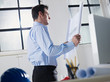 architect reading blueprint in office