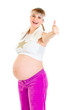 Photo: Smiling pregnant female in sportswear showing thumbs up Smiling pregnant female in sportswear showing thumbs up