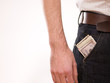A man putting american money in his pants pocket A man putting american money in his pants pocket