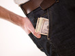 A man putting american money in his pants pocket A man putting american money in his pants pocket