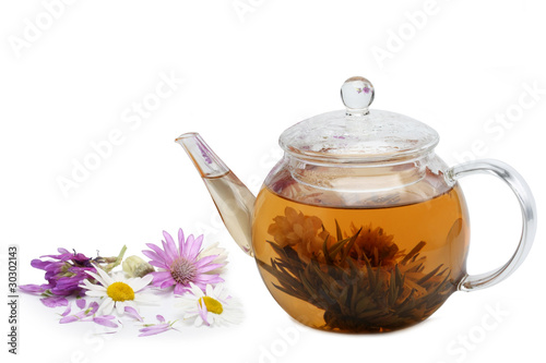 Photo: Teapot and cup of tea with a floral on a white background Teapot and cup of tea with a floral on a white background