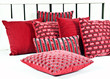 Combination of red and brown pillows on a bed with white linen