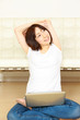 young woman sitting on floor and using laptop