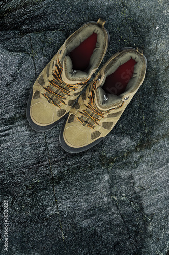 Photo: Walking boots on rock background Walking boots on rock background