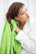 Beautiful young woman wipes her hairs