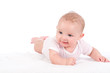 Baby liegt auf einer Decke und lächelt
