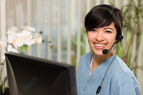 Photo: Attractive Multi-ethnic Young Woman Wearing Headset and Scrubs Attractive Multi-ethnic Young Woman Wearing Headset and Scrubs