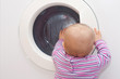 Baby schaut in die Wäschetrommel