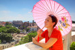 beautiful young woman with pink umbrella looks at Rome