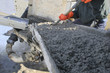Construction worker pouring cement into pump