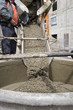 Truck operator pouring cement into crane bucket