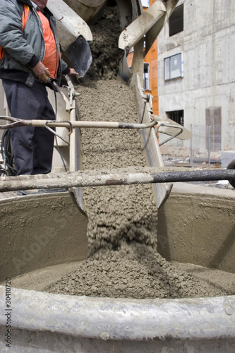 Photo: Truck operator pouring cement into crane bucket Truck operator pouring cement into crane bucket