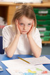Stressed Schoolgirl Studying In Classroom