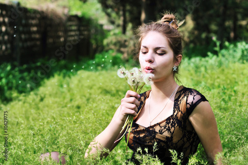 Photo: girl blowing on dandelions girl blowing on dandelions