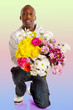 Young kneeling man with large bouquet of flowers