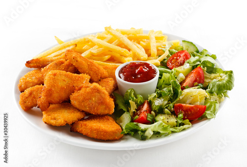 Foto: Fried chicken nuggets, French fries and vegetables Fried chicken nuggets, French fries and vegetables