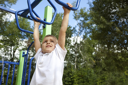 Photo: Boy playing on monkey bars Boy playing on monkey bars