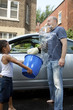 Father and son washing a car horseplay splashing Father and son washing a car horseplay splashing