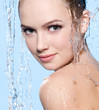 Beautiful young woman under the stream of water