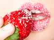 woman's mouth with red strawberry covered with sugar