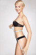 Young beautiful woman with measure tape on white