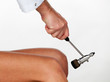 The neurologist testing knee reflex using a hammer