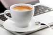 Cappuccino cup with spoon on laptop Cappuccino cup with spoon on laptop